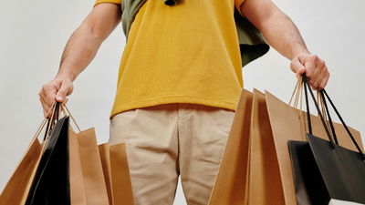 Deal Websites Feature Man Holding Shopping Bags