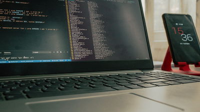 A photograph of a laptop with two terminal windows open.