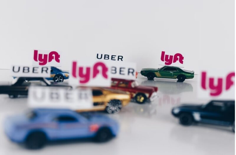 Lyft and Uber signs on model cars.