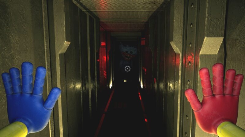 A screenshot from Poppy Playtime, showing the player throwing up red-and-blue-gloved hands while a terrifying creature stalks them in a long, metal corridor.