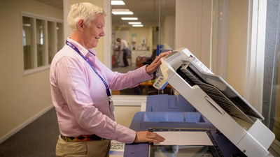Man using a large copier scanner.