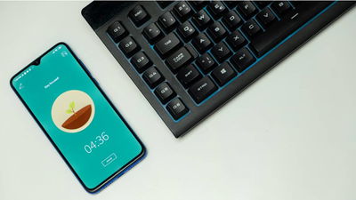 Phone sitting beside a keyboard.